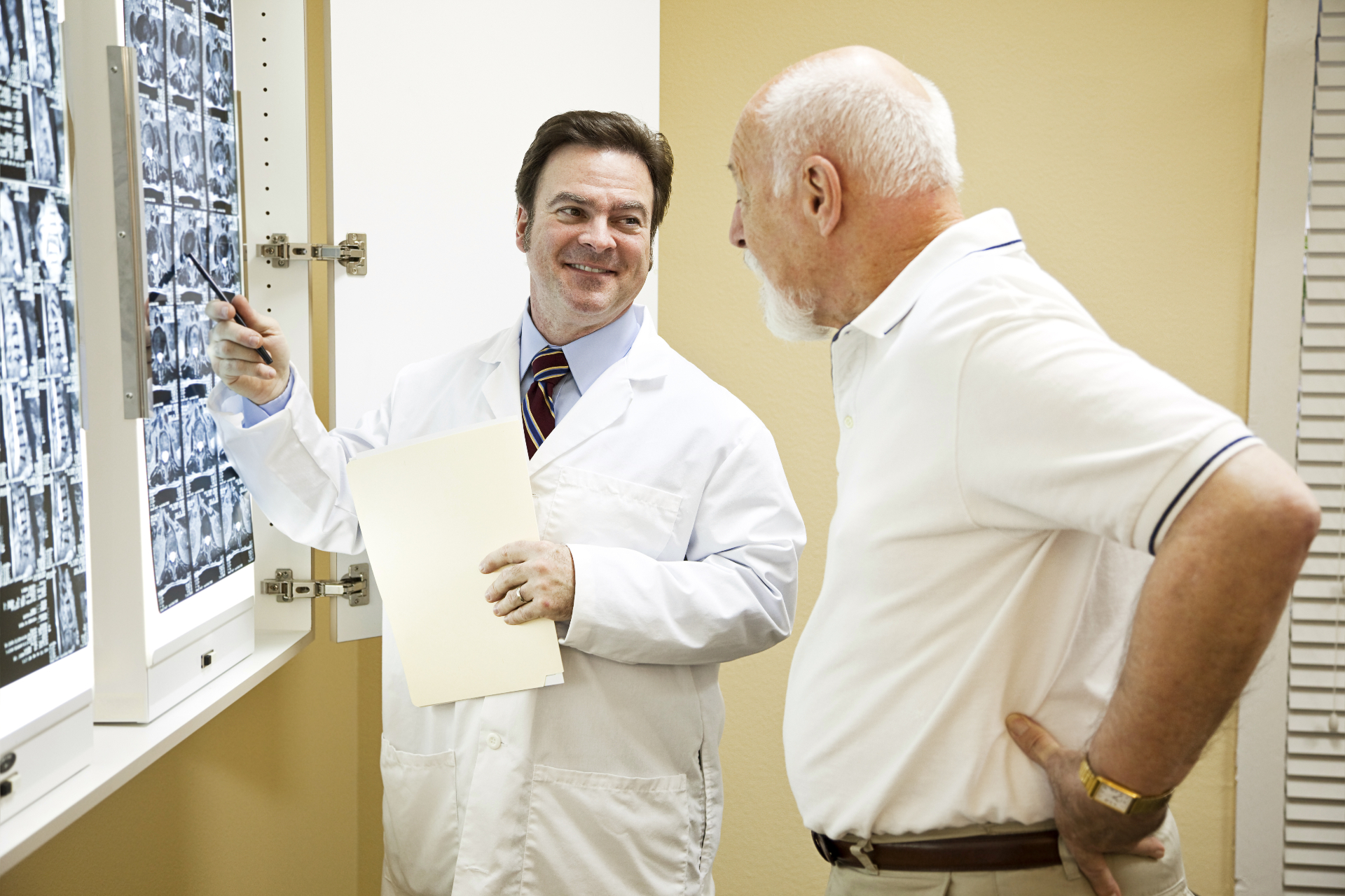 Spine specialist reviewing MRI scans with a patient