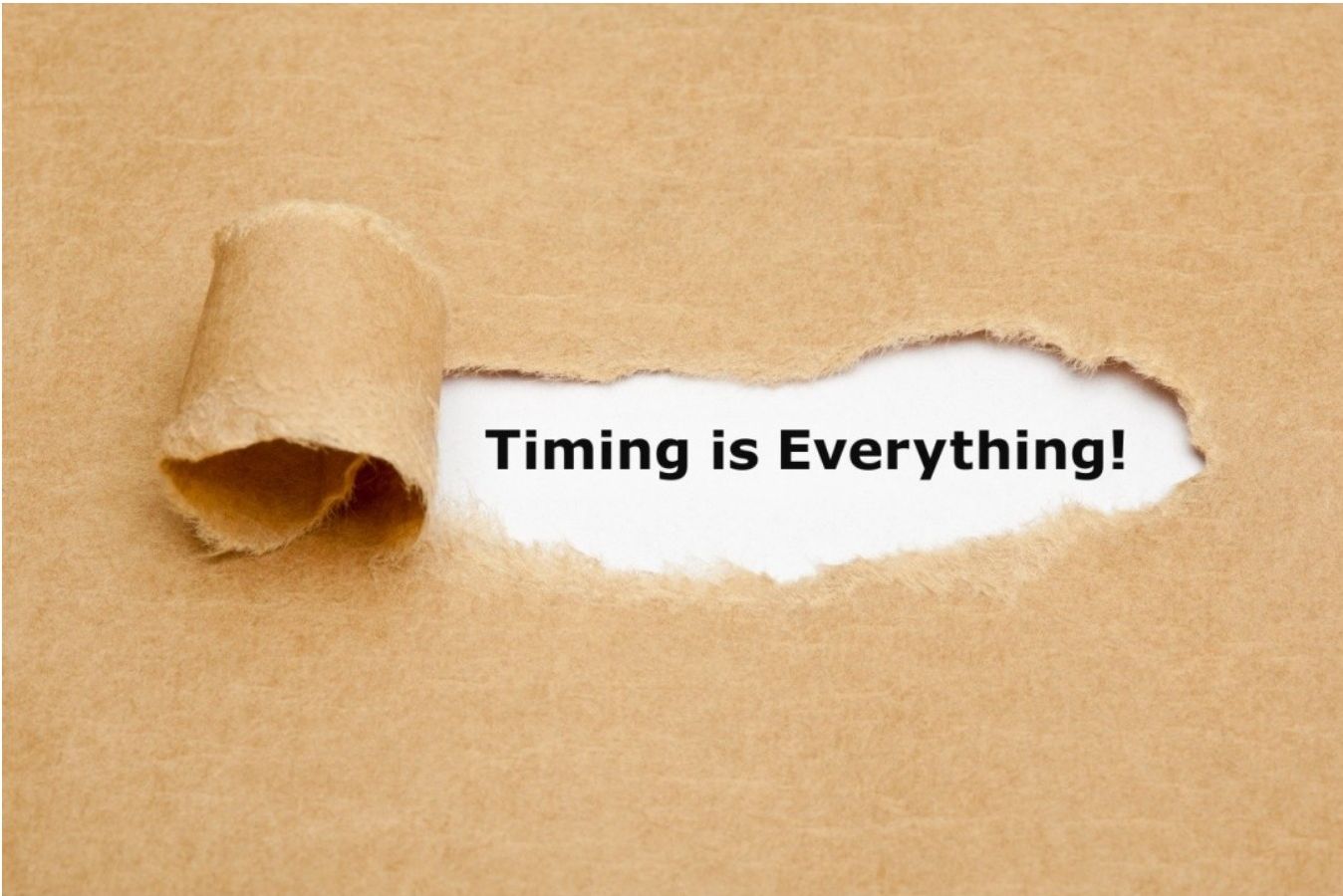 A torn piece of brown paper revealing the text Timing is Everything