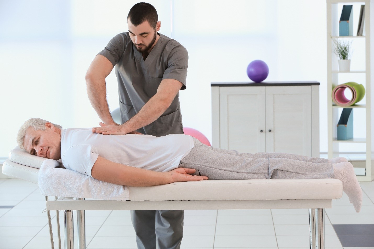Healthcare professional performing a spinal adjustment